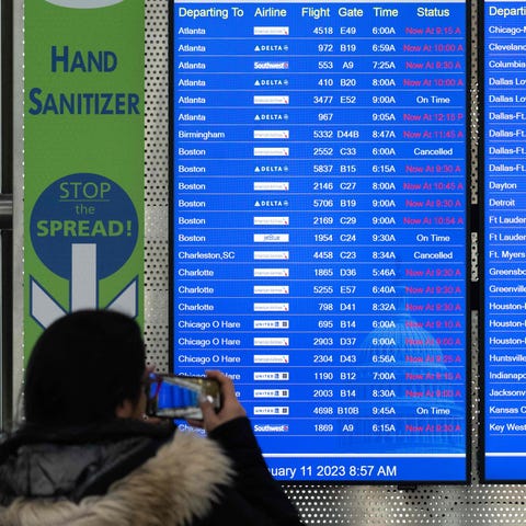 Travelers looks at a flight information display li