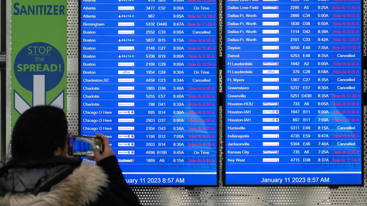 Travelers looks at a flight information display listing cancelled and delayed flights due to an FAA outage that grounded flights across the US at Ronald Reagan Washington National Airport in Arlington, Virginia, January 11, 2023. - The US Federal Aviation Authority  said Wednesday that normal flight operations "are resuming gradually" across the country following an overnight systems outage that grounded departures. (Photo by SAUL LOEB/AFP via Getty   Images)