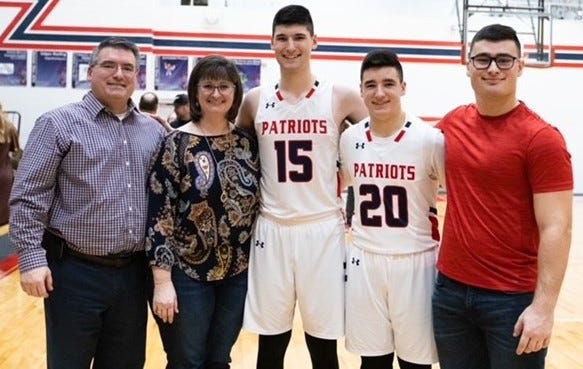 State Line Christian’s Eli Dyer (15, center) celebrates reaching 1,000 career points with his parents Josh and Emily and brothers Brandt (20) and Evan.