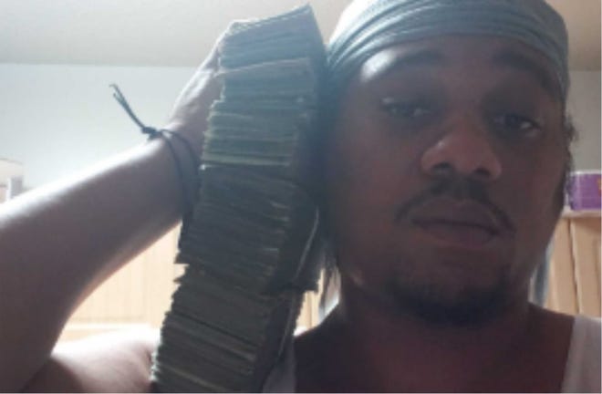Rolando Antuain Williamson posted this photo of himself posing with drug profits, one of the photos used to secure his conviction in federal court of running a drug network.