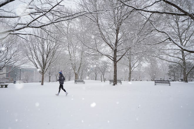 Max Leu, from downtown Columbus, goes for a run in the snow Sunday afternoon in Columbus' Topiary Park. A winter weather advisory has been issued for the Columbus area through the lunch hour Wednesday.