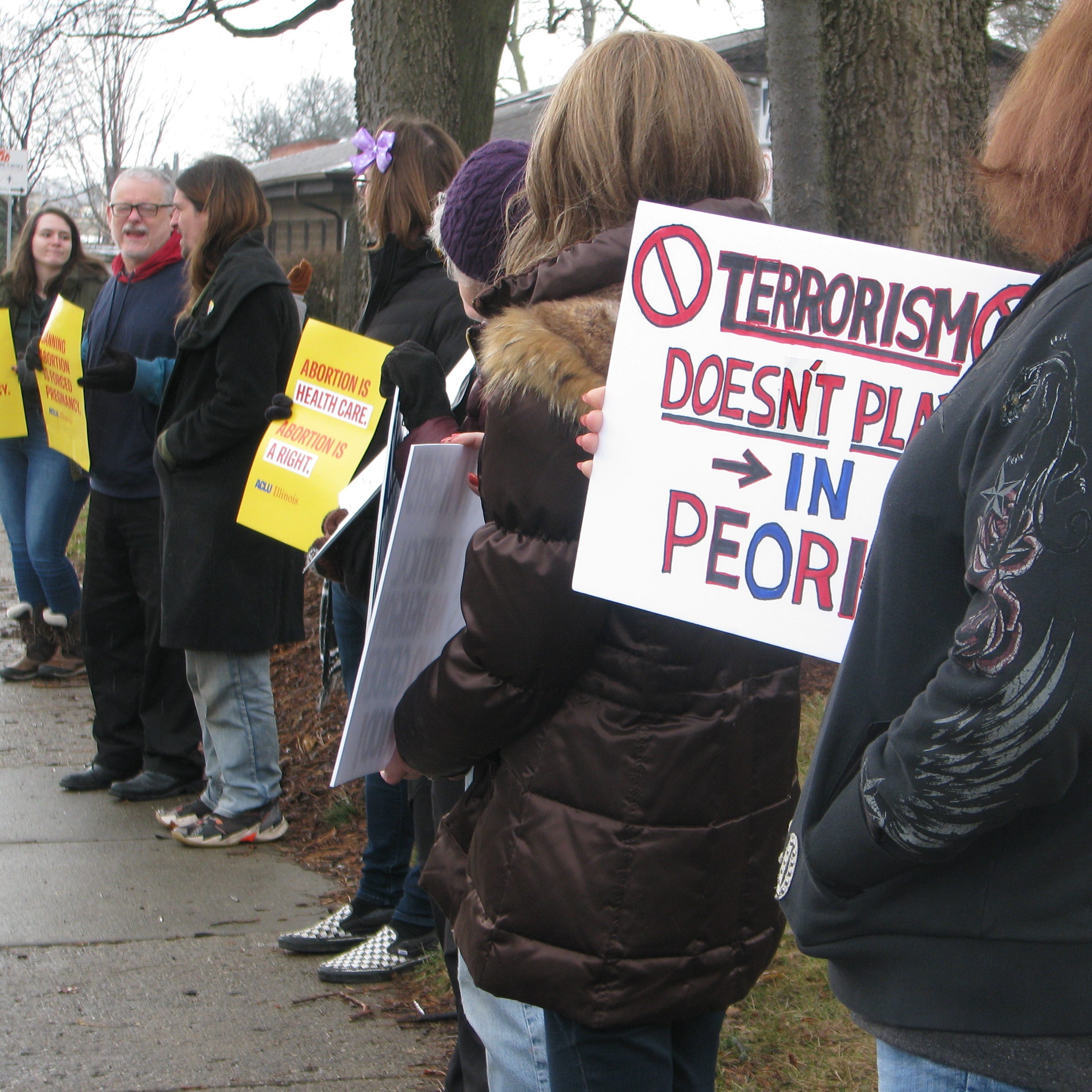 People stand outside the Planned Parenthood clinic on Sunday, Jan. 22,2023, during a rally to show support after someone set part of the building on fire last week.
