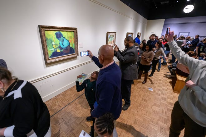 People catch a glimpse of the painting titled ‘The Novel Reader’ while visiting the ‘Van Gogh in America’ exhibition at the Detroit Institute of the Arts, in Detroit, January 22, 2023. A Brazilian art collector is seeking to recover the painting, claiming that it had been stolen after he had purchased it nearly six years ago.