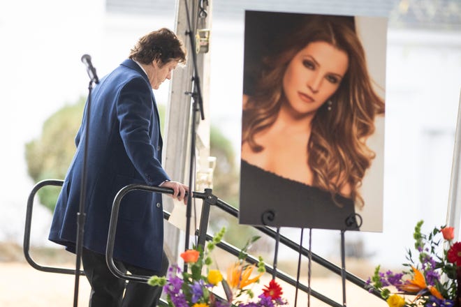 Jerry Schilling, a longtime associate of Elvis Presley, walks down from the stage and passes a photo of Lisa Marie Presley during the celebration of life for Lisa Marie Presley at Graceland in Memphis, Tenn., on Sunday, January 22, 2023. 
