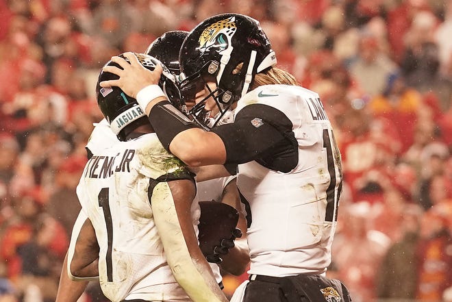 Jaguars running back Travis Etienne (1) is congratulated by Trevor Lawrence (right) after scoring a touchdown against the Kansas City Chiefs on Saturday in an NFL playoff divisional game.