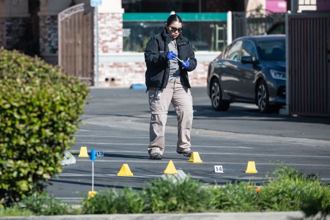 An LA County Sheriff forensics officer collects evidence in the parking lot behind the Star Dance Studio after a shooting on Saturday night left 10 dead on Sunday, Jan. 22, 2023 in Monterey Park, Calif. 