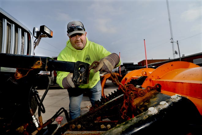 City of Springfield Public Works worker Art Behl hooks up a plow to one of the dump trucks at the Public Works Street Department Tuesday in preparation for the expected snow storm.