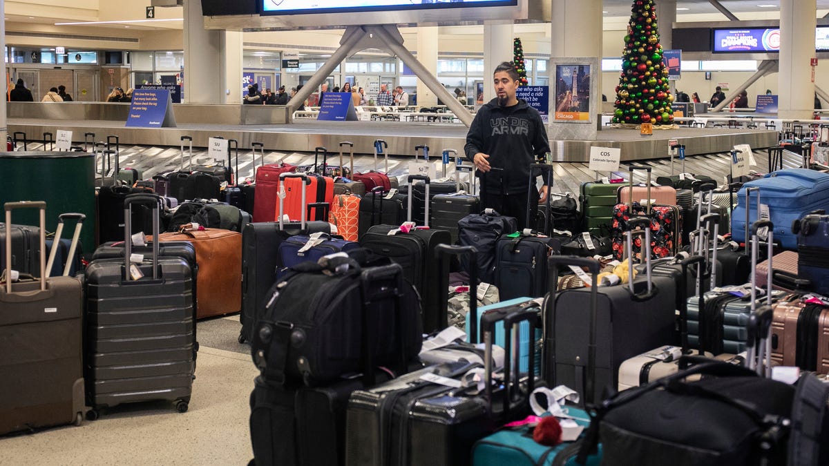 A person looks for lost luggage near the baggage carousel at Midway Airport in Chicago, Tuesday, Dec. 27, 2022, after Southwest Airlines flights were cancelled and delayed during a winter storm. Problems at Southwest Airlines appeared to snowball after the worst of the storm passed. It cancelled more than 70% of its flights Monday, more than 60% on Tuesday, and warned that it would operate just over a third of its usual schedule in the days ahead to   allow crews to get back to where they needed to be. (Pat Nabong /Chicago Sun-Times via AP)