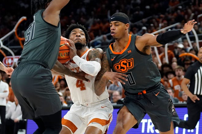 Tyrese Hunter of Texas is looking for a place to strike, while Oklahoma state guard John-Michael Wright defends.  With the win, the Longhorns improved to 17-3 overall and 6-2 in the Big 12.