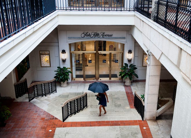 A pedestrian uses an umbrella during a storm at The Esplanade in this 2021 photo. Years of water intrusion has caused concrete damage to the building structure, and repairs are ongoing.
