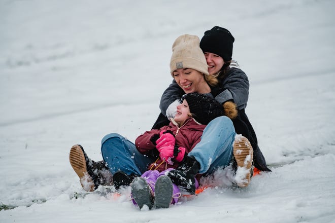 Brystol Griffin, 5, front, Kayden Hamlin, 20, middle, and her sister, Brooklyn, 16, enjoy a snow day together Wednesday at Deis Hill Park in Dover.