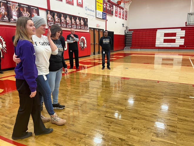 Bucyrus High School secretary Fran Swavel, center, along with her daughter, Jillian Symsick, left; and her co-worker, Justine Moodespaugh; enters a pep rally in the school gymnasium on Tuesday that was planned by DECA students in honor of her battle against cancer.