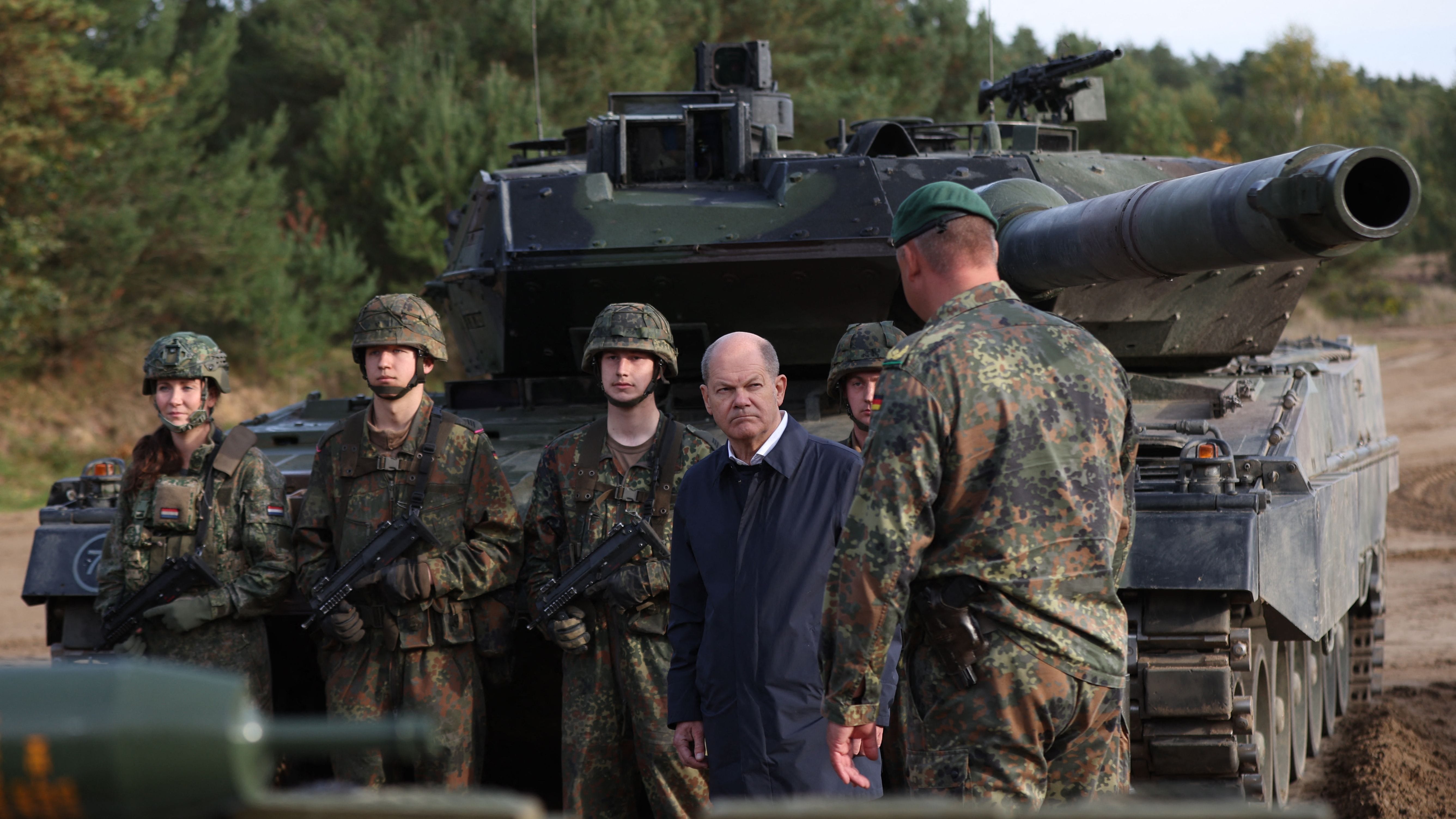 On October 17, 2022 shows German Chancellor Olaf Scholz (C) talking with soldiers in front of a Leopard 2 main battle tank during a training exercise at the military ground in Ostenholz, northern Germany.
