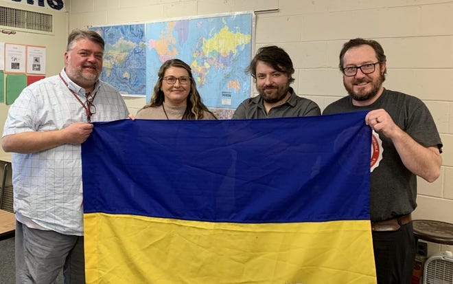 Holding the Ukraine flag is (from left) James Drew, Orchard Center High School principal; Kristina Johnston, OCHS student service provider; Ricky Cain, OCHS Class of 2004 graduate; and Christopher Kunder, OCHS social studies teacher. Cain works in the information technology industry and has been living in Ukraine during the war with Russia.