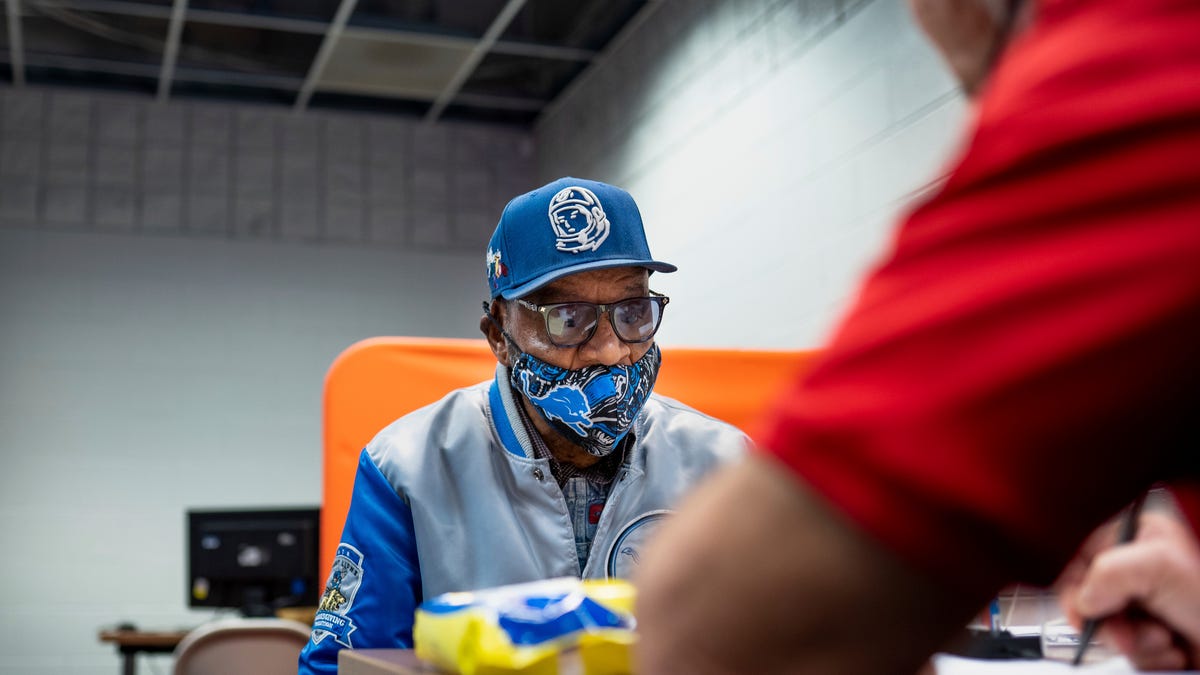 Detroit resident Cornelius Chatman talks with volunteer tax preparer Rick Pacynski while getting his taxes done for free at Ford Resource and Engagement Center-East in Detroit on Thursday, January 26, 2023.  