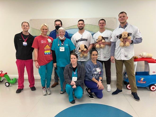 Blue Wahoos' Griffin Conine and Will Banfield (middle back row standing) along with hitting coach Matt Snyder and broadcaster Erik Bremer join with hospital nurses and doctors Jan. 19 during hospital visit as part of Fish Fest event.