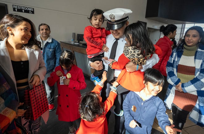 Prakash Poudyel is swarmed by his nieces, nephews and other family members following his swearing-in as a new Columbus police officer on Friday at the 138th recruit graduating class at the James G. Jackson Columbus Police Academy. Poudyel is the second Nepali police officer on the Columbus force.