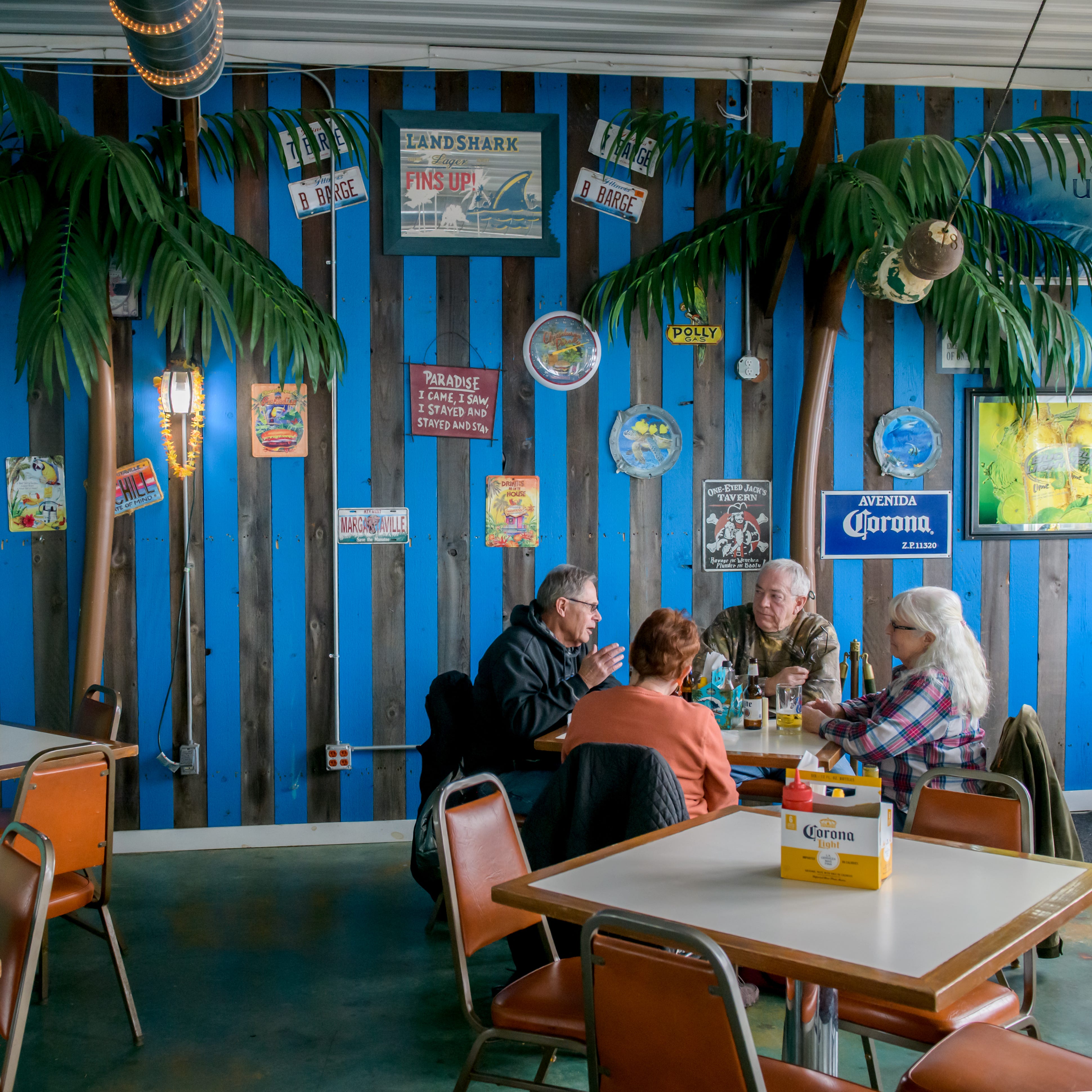With "palm trees" in the background, Rick Babitzke, left, and his wife Nel, second from left, of East Peoria, spend an afternoon with Bellevue friends Lee and Jane Farrar at the Burger Barge, 123 Meadow Avenue in East Peoria. 