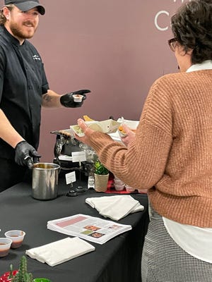 Chef instructor Michael Lyons prepares a sample of pulled pork for an attendee at Monday's Culinary Open House at Monroe County Community College.