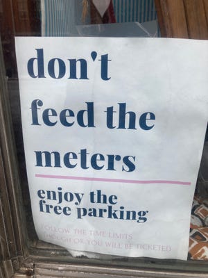 A "don't feed the meters" sign hang in the storefront of Springfield Vintage, 215 S. Fifth St.