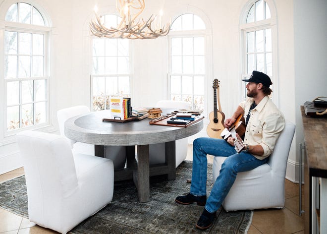 Chase Rice sits at a table in his home, where most of his songs are written "I hate cowboys and all dogs go to hell" was written on February 1, 2023 in Franklin, Tennessee.