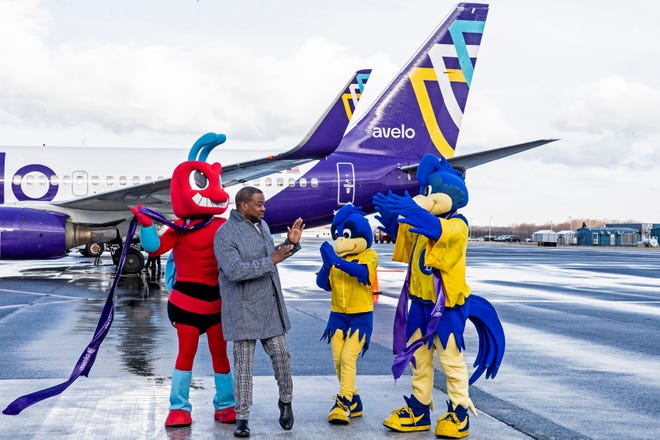 Chuck Creekmur, Co-founder and Co-CEO of AllHipHop.com, flanked by DSU mascot Too-Fly and UD mascots Baby Blue and YoUDee, have a moment after the ribbon cutting ceremony commemorating Avelo Airline's Boeing 737-700 first flight to Orlando, Fla., out of New Castle Airport in Wilmington, Wednesday, Feb. 1, 2023. Avelo's inaugural flight marks the return of commercial flight services to Delaware and will offer non-stop trips to five Florida locations.