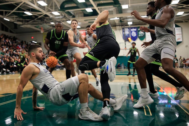 University of North Florida guard Jose Placer (left) goes to the floor with Jacksonville University's Jarius Cook during their recent game at Swisher Gym. The two teams close their ASUN regular-season schedules this week with two home games.