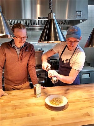 Pulito Osteria executive chef Chaz Lindsay (right) adds the perfect seasonings to a dish of Cacio e Pepe, a made-from-scratch pasta recipe, as general manager Jonathan Webb looks on.