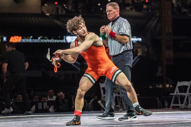 OSU wrestler Daton Fix celebrates with a home run swing after beating Michigan's Dylan Ragusin on Friday night in the Bout at the Ballpark at Globe Life Field in Arlington, Texas.