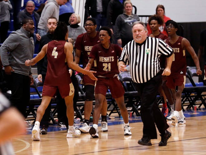 Jayden Griffith, left, is congratulated by Ezra Bobo following Licking Heights' 48-47 win against host Zanesville on Friday night at Winland Memorial Gymnasium. Griffith's putback with 2.8 seconds left proved to be the difference as the Hornets snapped Zanesville's five-game winning streak.