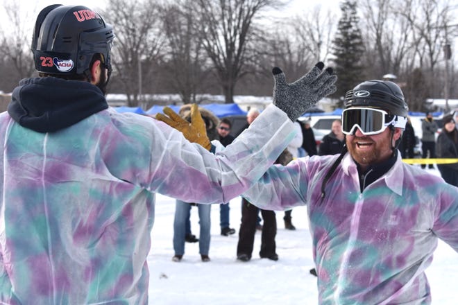 Outhouse race participants Chris Bujaki, left, and Rick Ender congratulate each other after winning a heat Saturday, Feb. 4, 2023, during the annual outhouse races at the Devils Lake Tip-Up Festival. This year's races were held on land next to the Manitou Beach Marina and not on the ice because of safety reasons.