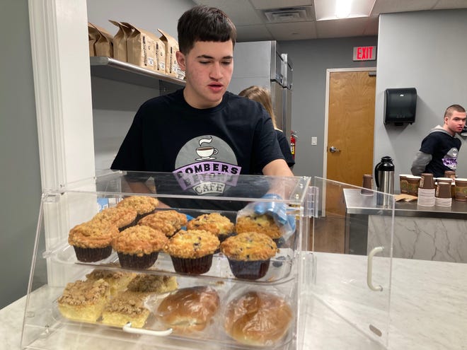 Bombers Beyond Café Brew Crew member Jayvon serves muffins at the café.