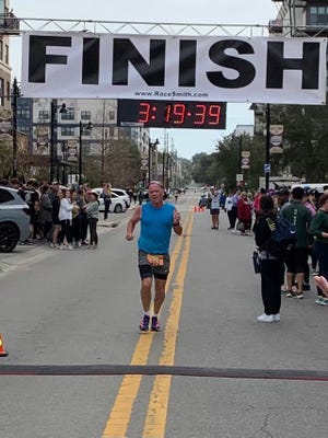 Tallahassee's Jack McDermott crosses the finish line during Sunday's Tallahassee Marathon.