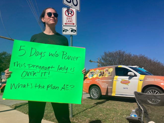 Katy Manganella, 37, protests in front of an Austin Energy truck in her neighborhood in Austin, Texas, Sunday, Feb. 5, 2023. Thousands of Austin residents remained without power days after an ice storm knocked out electricity to nearly a third of the city's customers.