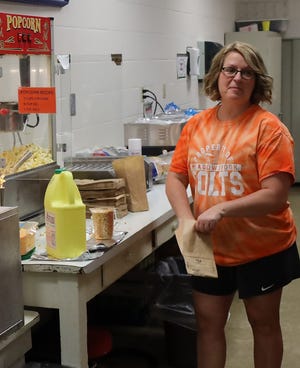 Meadowbrook's Crystal Dudley prepares popcorn in the concession game during a recent Meadowbrook High School boys basketball game. She has been supporting student athletes in the district for 15 years.