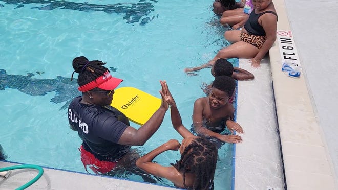 An instructor high-fives a student during a 2022 water safety course at the James Weldon Johnson Family YMCA. The branch celebrates its 75th anniversary this year and was the first location serving the Black community in Jacksonville.