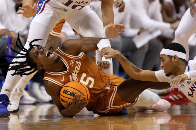 Kansas guard Dajuan Harris, right, tries to steal the ball away from Texas guard Marcus Carr during the first half of the Jayhawks' 88-80 win Monday night at Allen Fieldhouse. Texas retained its Big 12 lead but only by a razor-thin half-game over idle Iowa State.