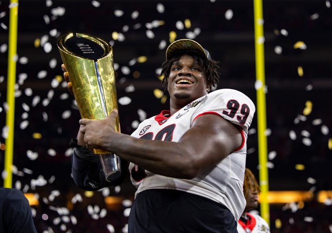 Jan 10, 2022; Indianapolis, IN, USA; Georgia Bulldogs defensive lineman Jordan Davis (99) celebrates with the championship trophy after defeating the Alabama Crimson Tide in the 2022 CFP college football national championship game at Lucas Oil Stadium. Mandatory Credit: Mark J. Rebilas-USA TODAY Sports