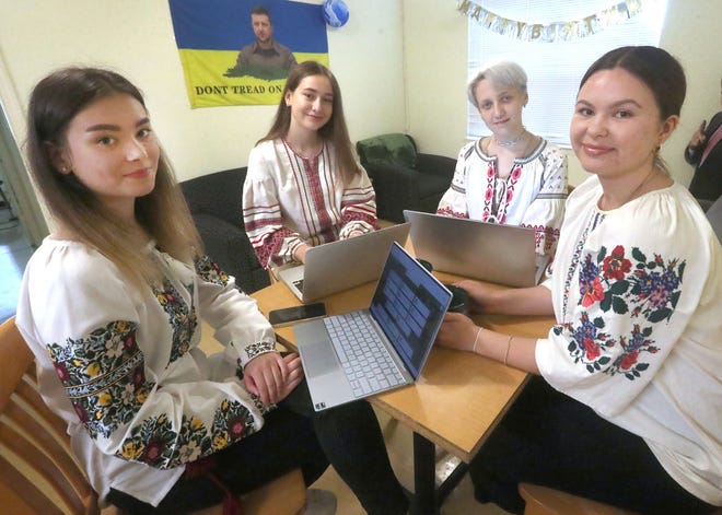 Students, from left, Yana Verbova, Yuliia Balan, Genevia Gayden and Veronika Shchur, all from Ukraine, sit together in their DeLand apartment recently. They each wore colorful vyshyvankas, traditional Ukrainian embroidered blouses. All four are at Stetson on scholarships established after faculty expressed a desire to help Ukraine after it came under attack by Russia in February 2022.