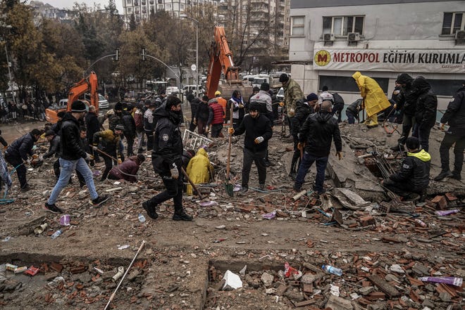 People and emergency teams search for people in the rubble in a destroyed building in Gaziantep, Turkey.