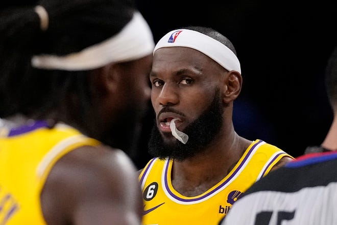 Los Angeles Lakers forward LeBron James, right, looks toward the camera as guard Patrick Beverley walks by during the first half of an NBA basketball game against the Oklahoma City Thunder Tuesday, Feb. 7, 2023, in Los Angeles. (AP Photo/Ashley Landis)