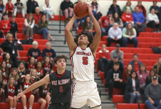 Moon's Elijah Guillory (5) goes for layup after getting around West Allegheny's Brady Miller (3) during the second half Tuesday night at Moon Area High School.
