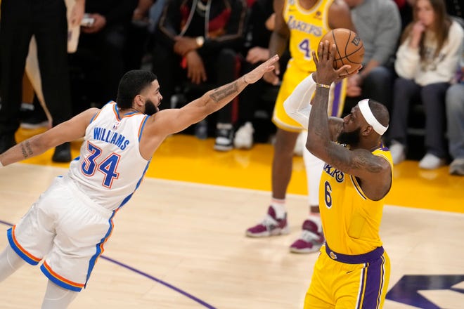Los Angeles Lakers forward LeBron James, right, shoots as Oklahoma City Thunder forward Kenrich Williams defends during the first half of an NBA basketball game Tuesday, Feb. 7, 2023, in Los Angeles. (AP Photo/Marcio Jose Sanchez)