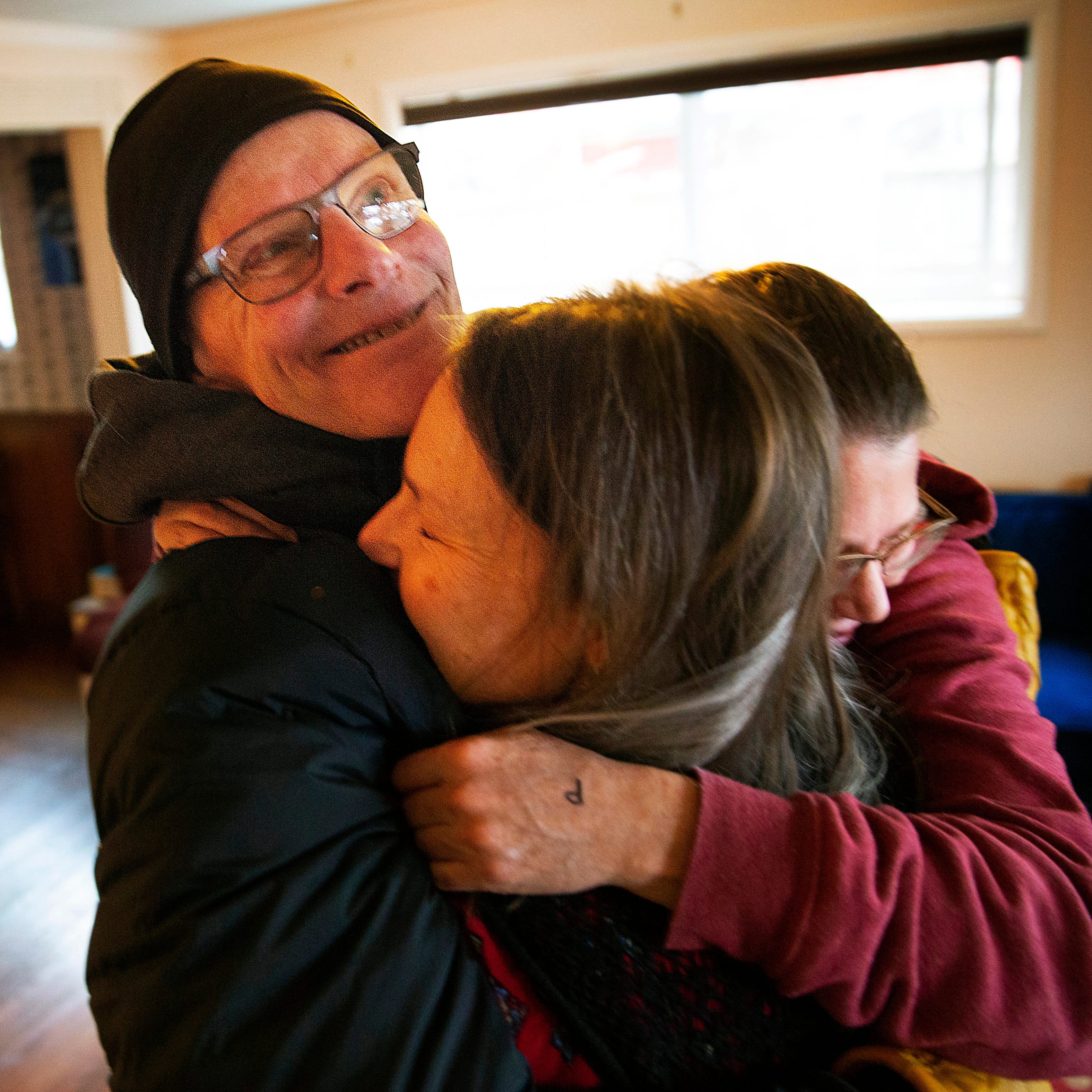 Steve Connelly, left, shares an embrace with death doula Amy May and his wife Becky Connelly after a counseling session in January. Steve is battling pancreatic cancer.