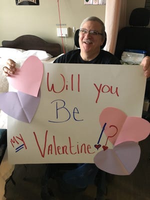 Spokane Veterans Home resident Gary Wright, who's lived at Washington facility for five years, poses with a large Valentine's card he received through the facility's annual Valentines for Veterans program.