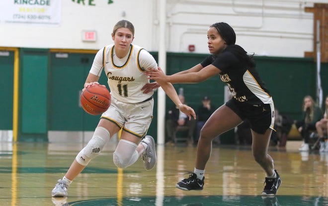 Blackhawk's Alena Fusetti (11) drives to the basket while being guarded by Quaker Valley's Zora Washington (5) during the first half Wednesday night at Blackhawk High School.