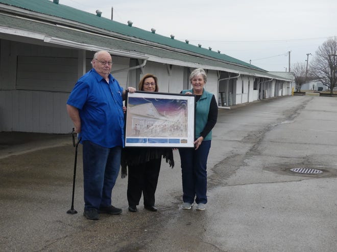 The Ross County Fair Committee stands in front of the current commercial event center with a model of the new proposed event center on Feb. 7, 2023.