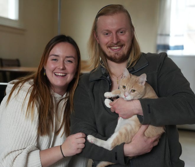Bruno the cat, and his new family Catherine and Andrew. Bruno went viral after he was returned to a shelter for being "too affectionate.” Here he plays with his new family on February 9, 2023.