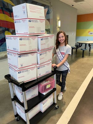 Nonprofit organization Lisowe's lights founder Amelia Lisowe, 12, loads up lights that were boxed at a packing party at the Saline County Boys and Girls Club in Benton, Arkansas, in summer 2022.