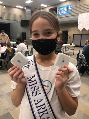 Amelia Lisowe, 12, founder of Arkansas-based Lisowe's Lights, holds night lights at a packing party with a local Cub Scout group in Bryant, Arkansas, in April 2021.